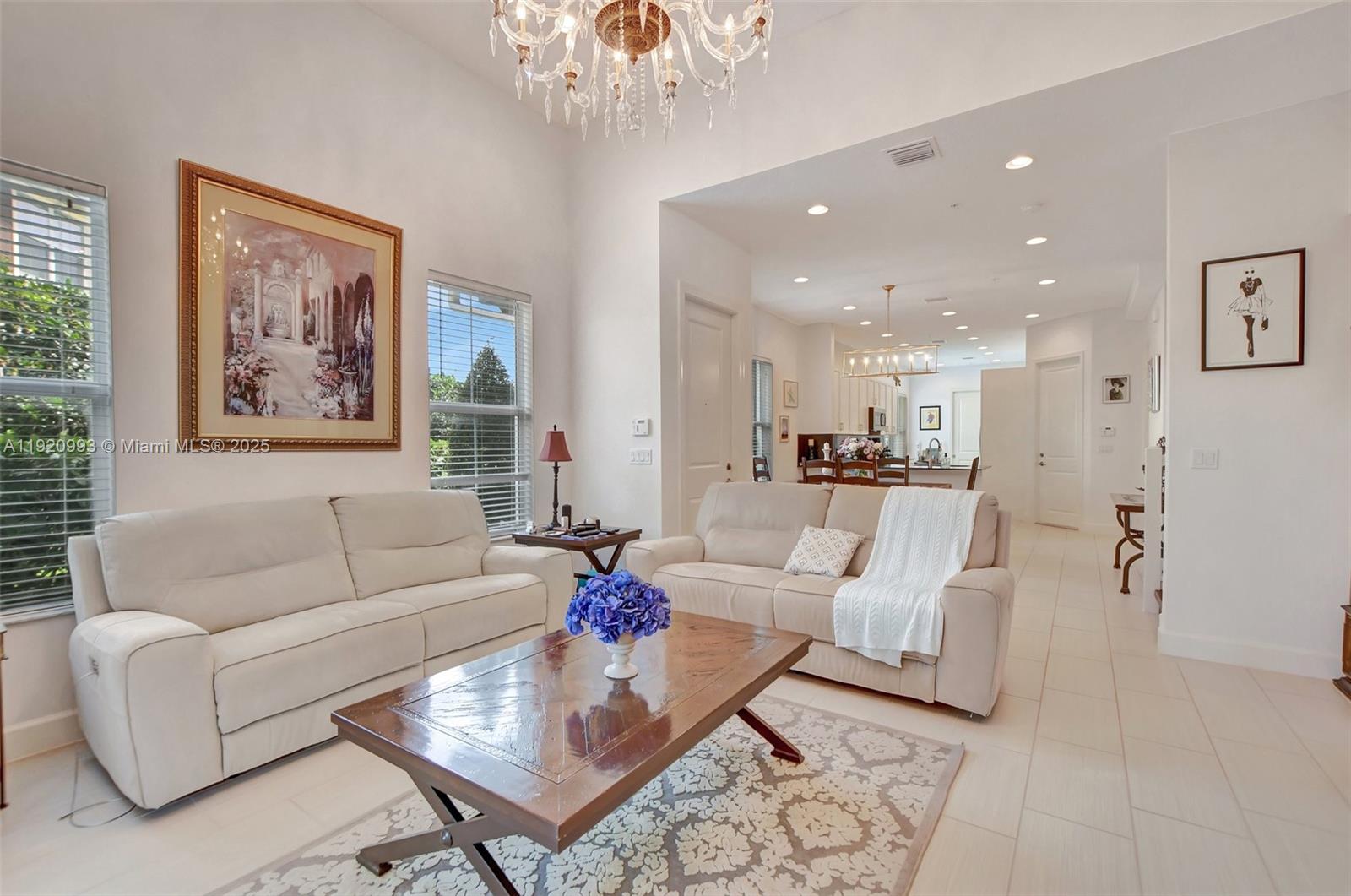 6657 Quiet Wave Trail, Unit 100 Boca Raton, FL 33433 - Photo 5 of 40 a living room with furniture and a chandelier