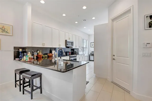 a kitchen with stainless steel appliances granite countertop a sink and a stove
