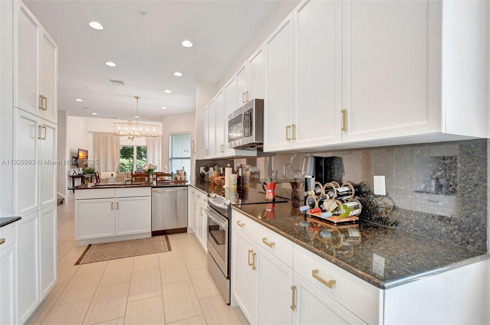 6657 Quiet Wave Trail, Unit 100 Boca Raton, FL 33433 - Photo 8 of 40 a kitchen with cabinets and window