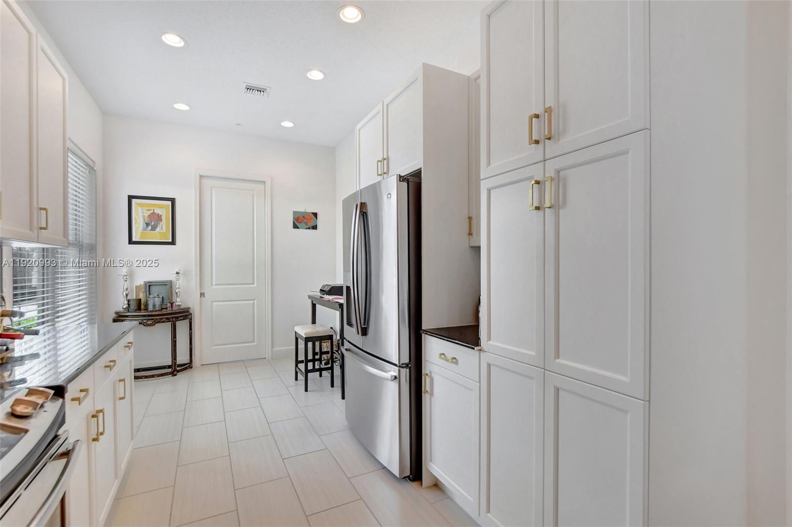 6657 Quiet Wave Trail, Unit 100 Boca Raton, FL 33433 - Photo 9 of 40 a view of a kitchen with furniture and a refrigerator
