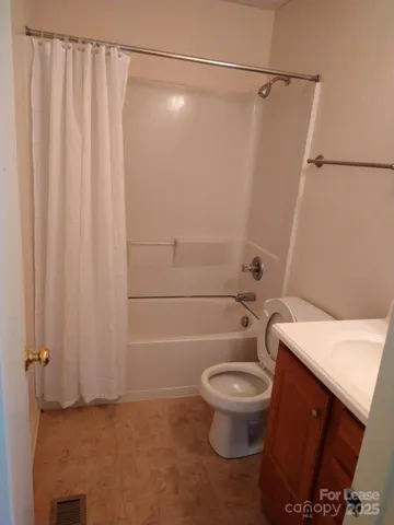 a white toilet sitting next to a shower