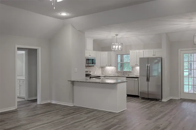 a kitchen with stainless steel appliances granite countertop a stove and a refrigerator