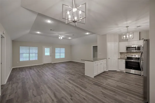 a view of a kitchen with cabinets and wooden floor