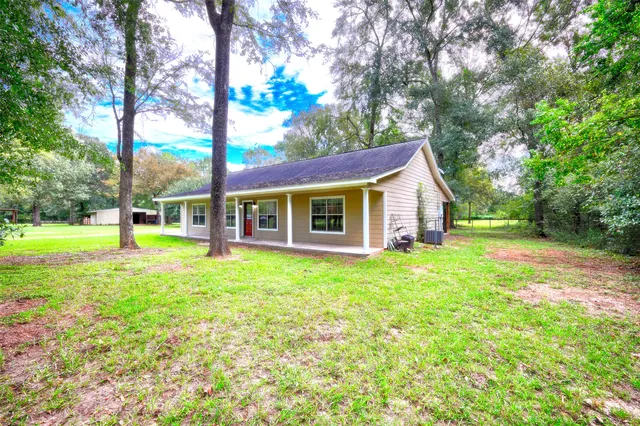 a view of a house with backyard and a tree