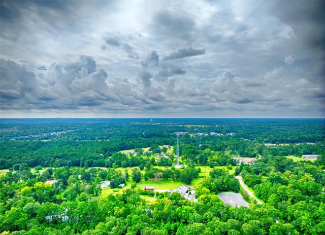 an aerial view of residential house with outdoor space and trees all around