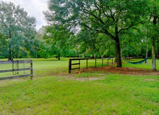 a view of a grassy field with benches in background