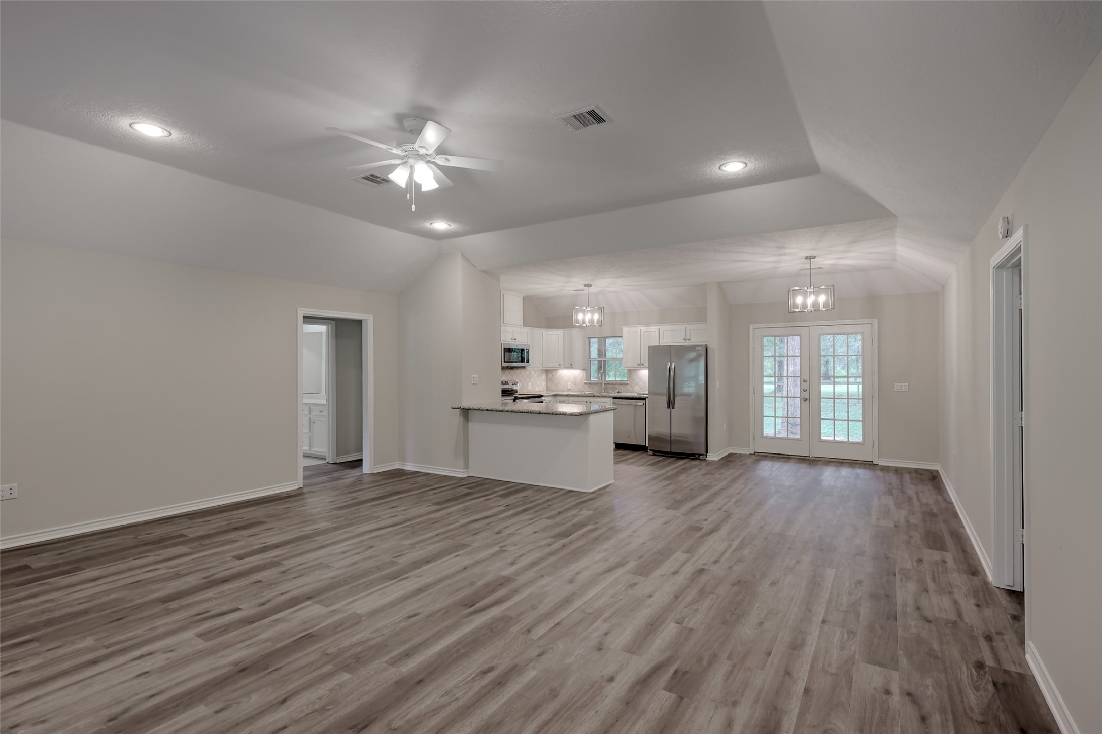 3131 Sapp Road Conroe, TX 77304 - Photo 9 of 48 wooden floor in an empty room with a kitchen