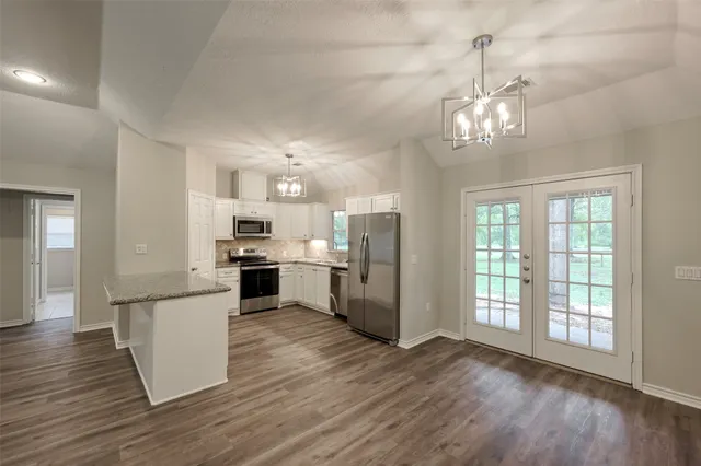 a view of a kitchen with a sink dishwasher a refrigerator and wooden floor
