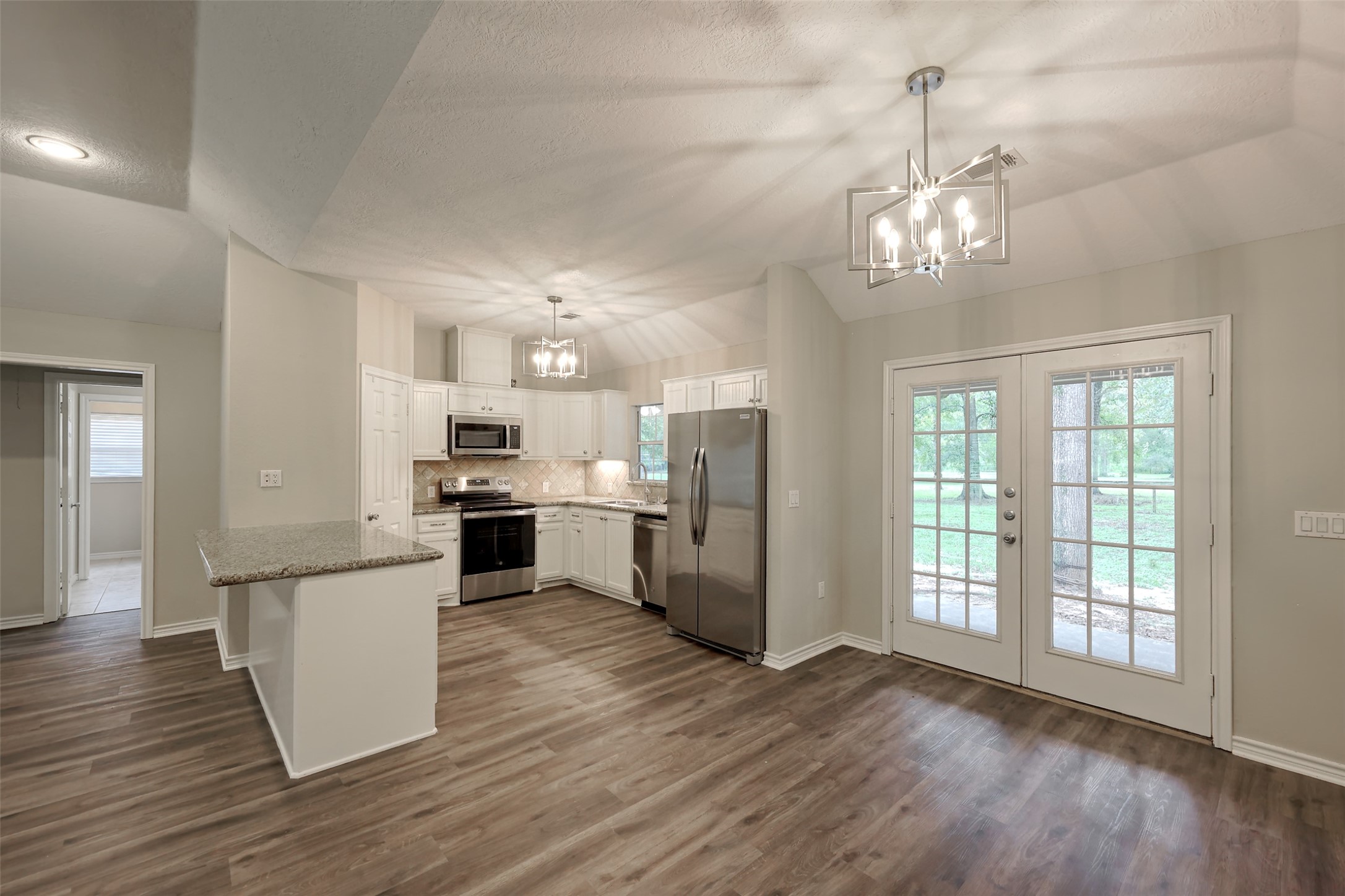 3131 Sapp Road Conroe, TX 77304 - Photo 10 of 48 a view of a kitchen with a sink dishwasher a refrigerator and wooden floor