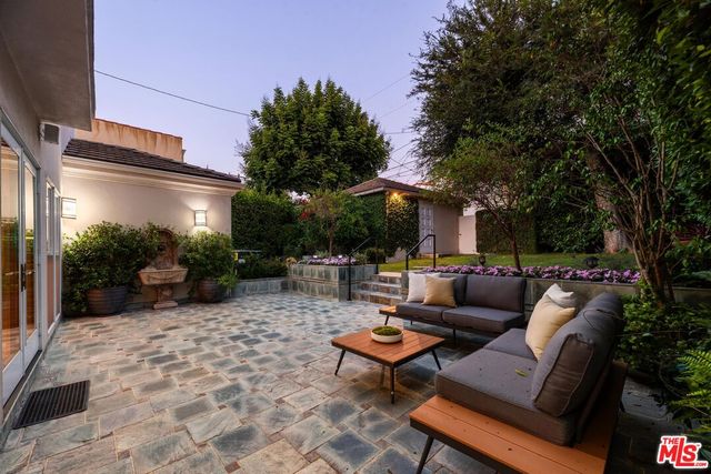a backyard of a house with fountain table and chairs