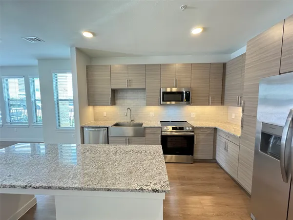 a kitchen with stainless steel appliances granite countertop a sink stove and refrigerator