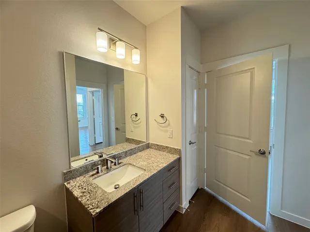 a bathroom with a granite countertop sink toilet and shower