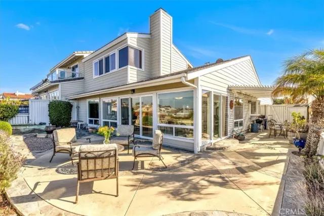 a patio with a table and chairs and potted plants