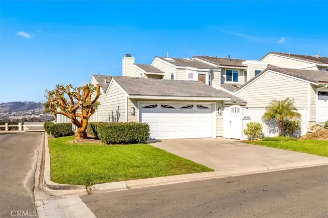 a front view of a house with a garden and yard