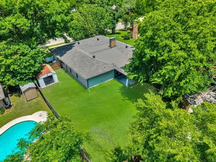 an aerial view of a house with yard and swimming pool