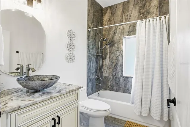 a bedroom with a bed and a flat tv screen on the dresser