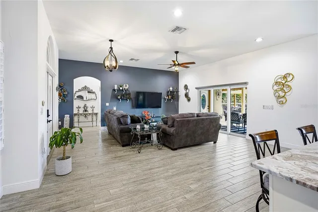a kitchen with stainless steel appliances kitchen island granite countertop a table chairs and a refrigerator