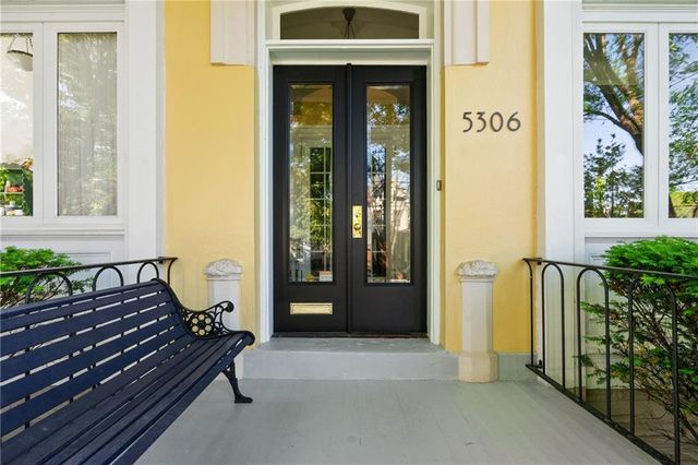 a view of a house with a door and wooden bench