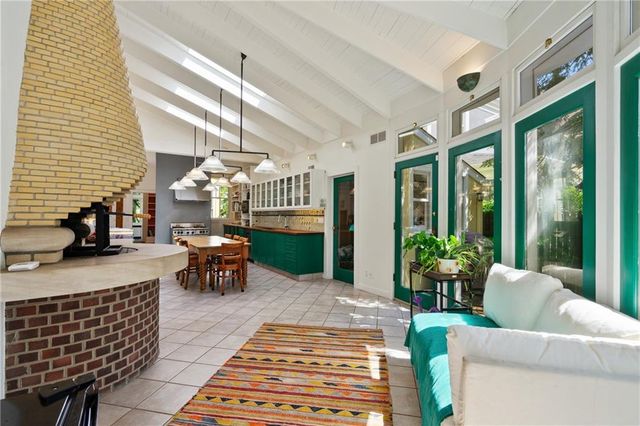 a kitchen with stainless steel appliances a sink a counter top space a dining table and chairs