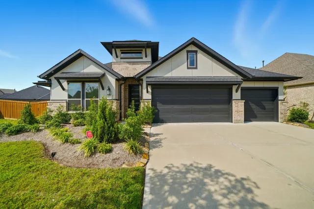 a front view of a house with a yard and potted plants