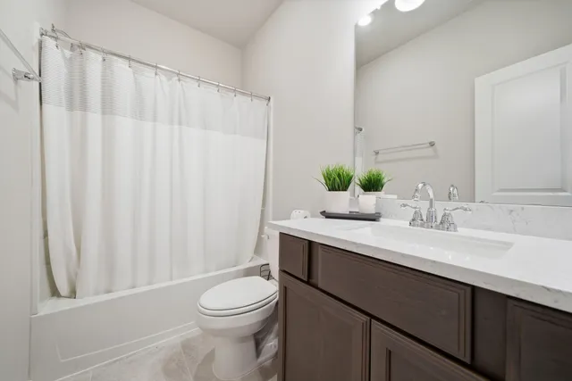 a bathroom with a sink a toilet and shower curtain