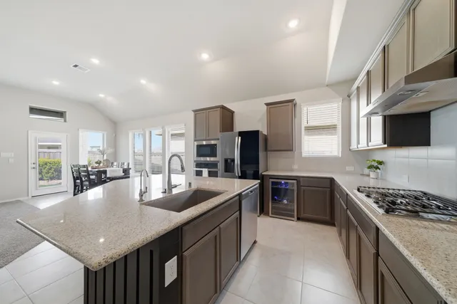 a kitchen with stainless steel appliances granite countertop a sink stove and refrigerator
