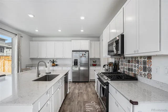 a kitchen with stainless steel appliances granite countertop a sink stove and refrigerator