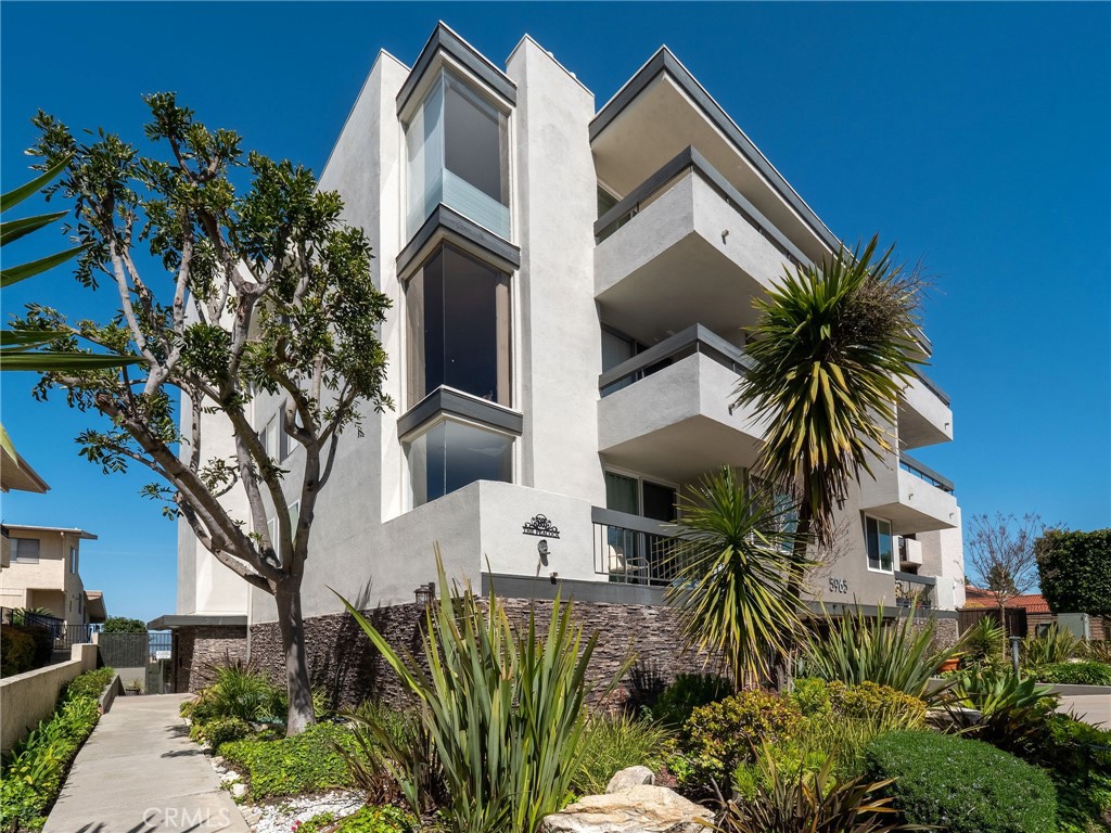 5965 Peacock Ridge Road, Unit 403 Rancho Palos Verdes, CA 90275 - Photo 1 of 1 a view of a house with a palm tree and flower plants