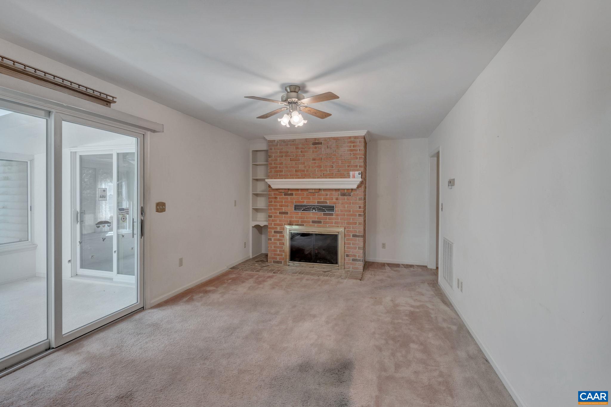 9795 Critzer Shop Road Afton, VA 22920 - Photo 11 of 22 a view of a livingroom with a kitchen and a ceiling fan a fireplace