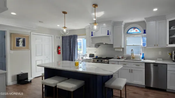 a kitchen with kitchen island granite countertop a sink cabinets and refrigerator