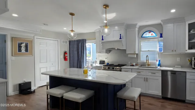 a kitchen with kitchen island granite countertop a sink cabinets and refrigerator