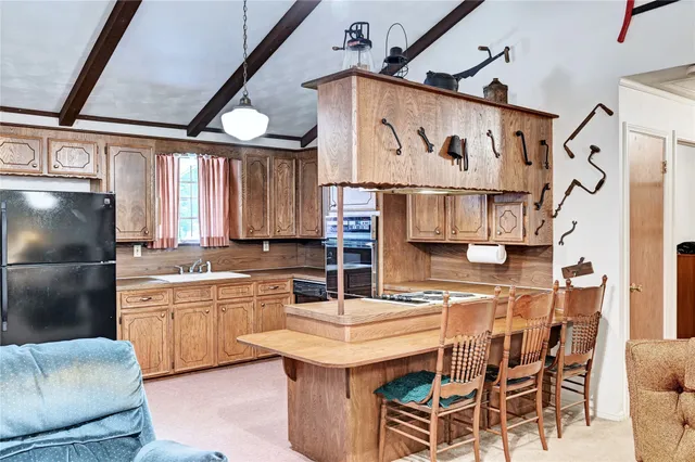 a kitchen with stainless steel appliances granite countertop a sink and a refrigerator
