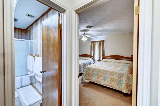 a bedroom with a bed and a glass door shower