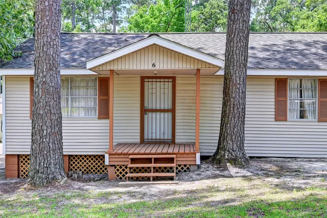 a small barn with a small yard and a large window