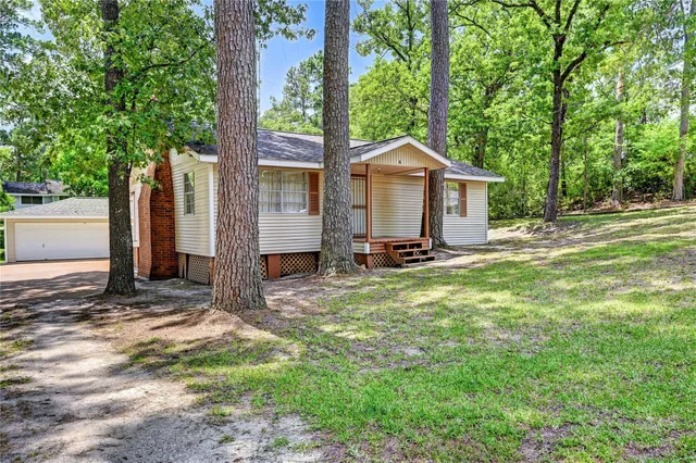 a view of a house with backyard and a tree