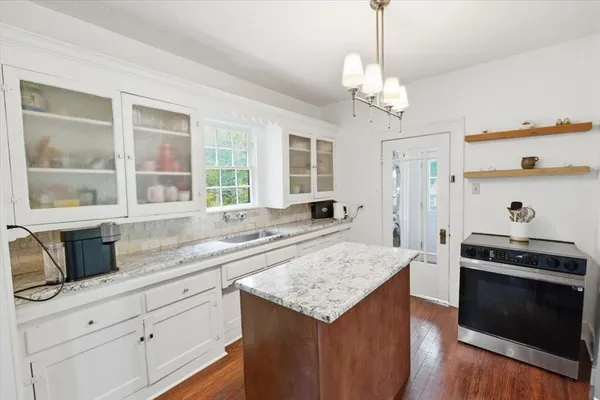 a living room with stainless steel appliances kitchen island granite countertop furniture and a wooden floor