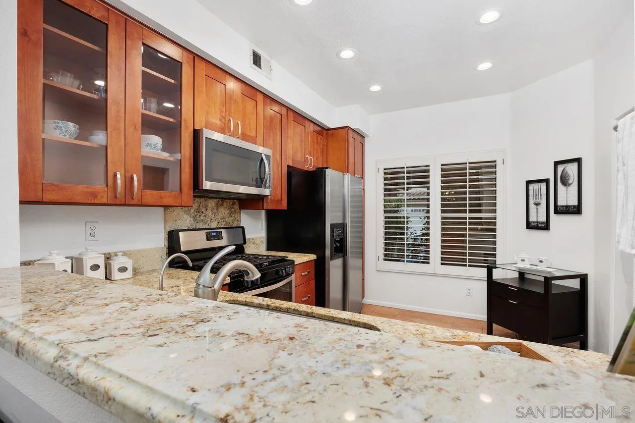 3965 Via Holgura San Diego, CA 92130 - Photo 11 of 45 a kitchen with stainless steel appliances granite countertop a stove and a sink