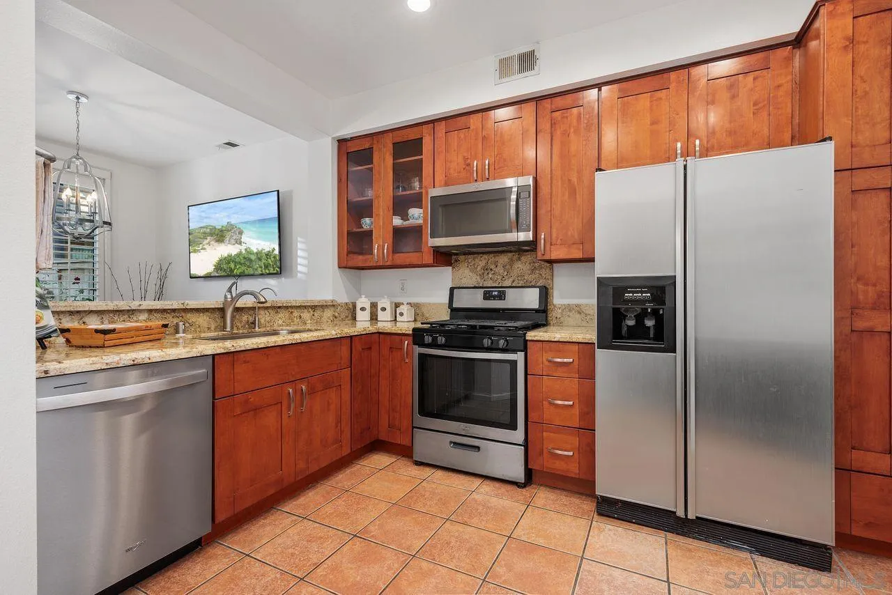 3965 Via Holgura San Diego, CA 92130 - Photo 12 of 45 a kitchen with stainless steel appliances granite countertop a refrigerator and a sink