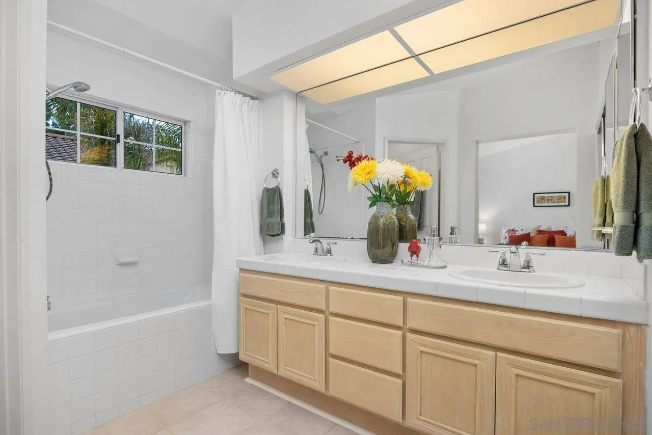 3965 Via Holgura San Diego, CA 92130 - Photo 22 of 45 a bathroom with a sink double vanity granite tub shower and a mirror