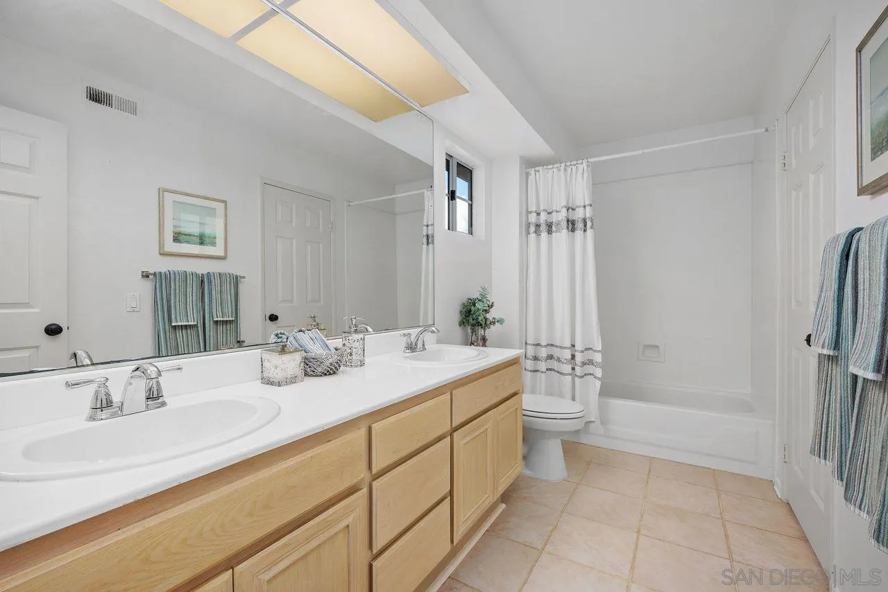 3965 Via Holgura San Diego, CA 92130 - Photo 26 of 45 a bathroom with a double vanity sink and mirror