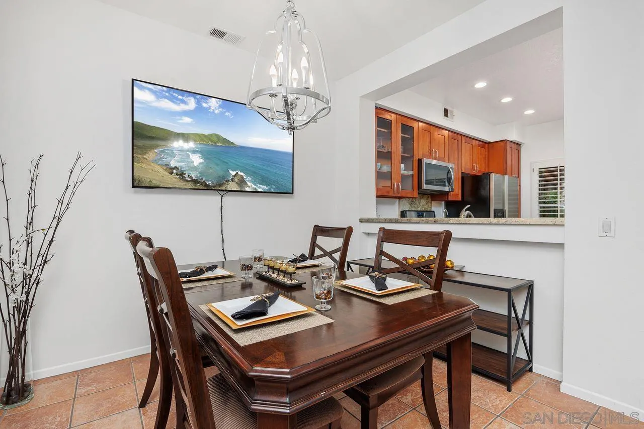 3965 Via Holgura San Diego, CA 92130 - Photo 10 of 45 a view of a dining room with furniture a chandelier and wooden floor