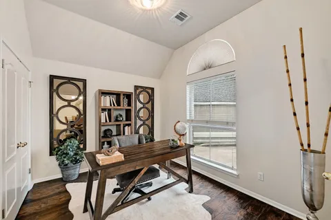a view of a workspace with furniture and a window