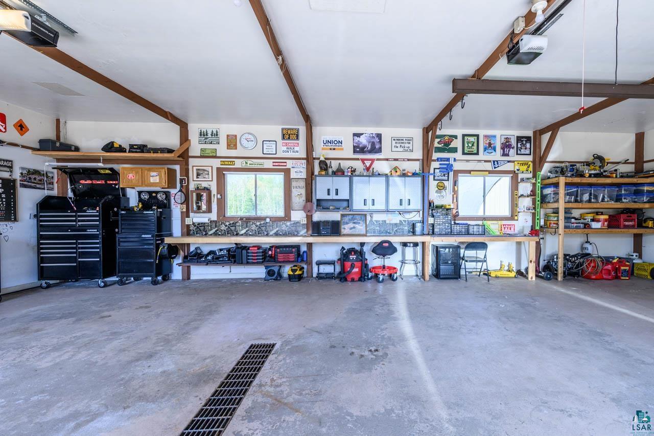 2581 O'Rourke Road Hibbing, MN 55746 - Photo 32 of 61 Spacious garage with concrete flooring, exposed wood beams, built-in shelving, two windows, and overhead lighting