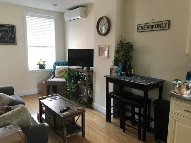 a living room with furniture a window and a flat screen tv