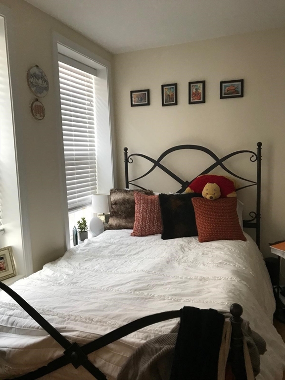 6 Baldwin Place Boston, MA 02113 - Photo 12 of 16 a bedroom with a bed and wooden floor