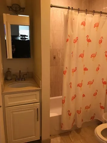 a bathroom with a granite countertop sink toilet and shower