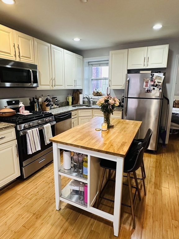6 Baldwin Place Boston, MA 02113 - Photo 2 of 16 a kitchen with a stove a refrigerator and wooden floor