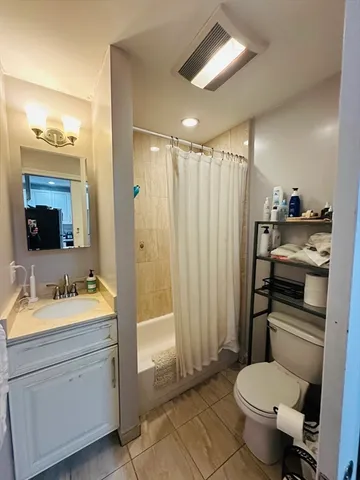 a bathroom with a sink toilet double vanity and tub
