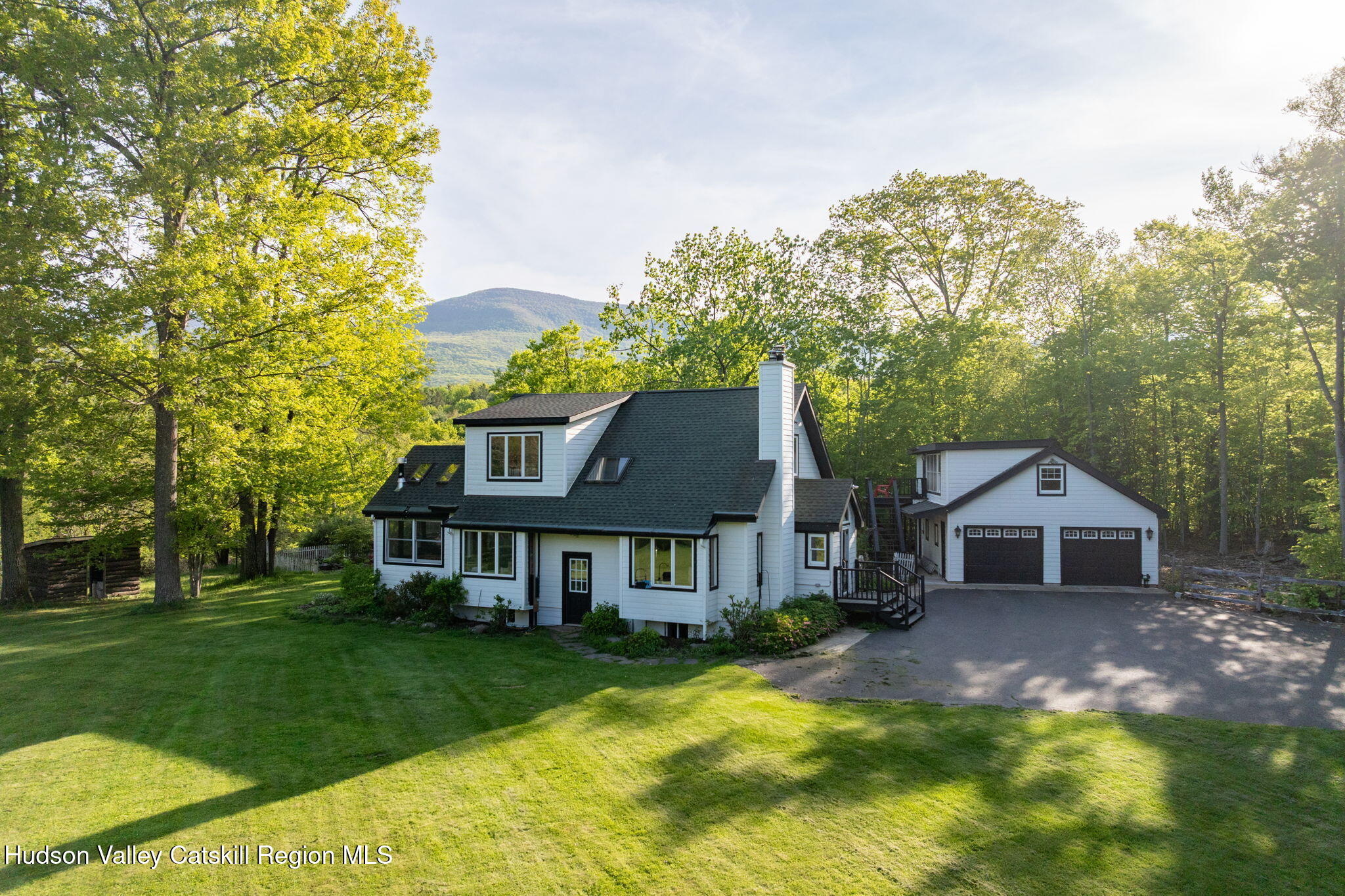 a front view of a house with a yard and trees