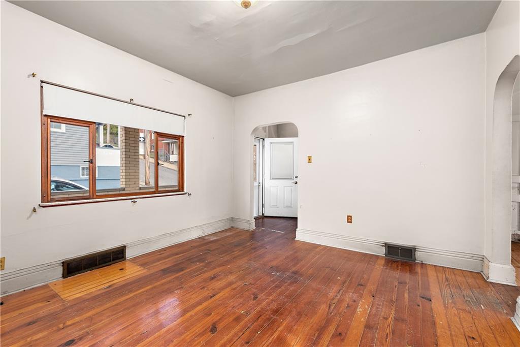 801 Frank Street McKees Rocks, PA 15136 - Photo 7 of 25 a view of an empty room with wooden floor and a window